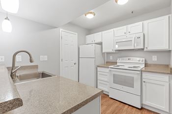 a kitchen with white appliances  at The Buttes Apartments Loveland, Colorado